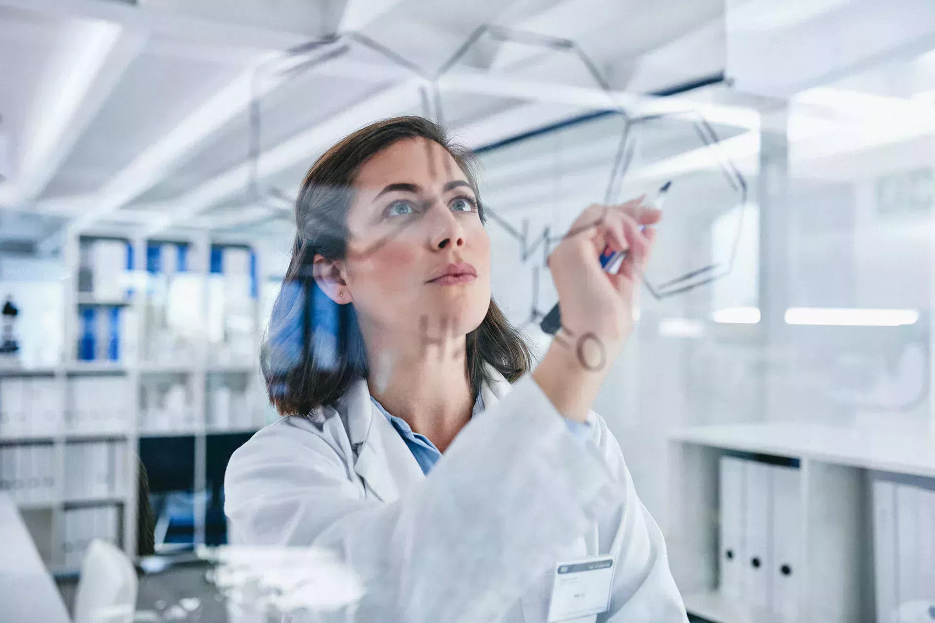 Femme dans un laboratoire qui écrit quelque chose sur un tableau