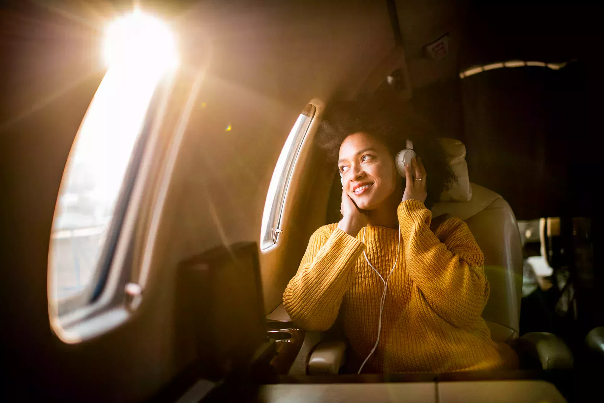 Femme assise dans un avion et écoutant de la musique avec des écouteurs